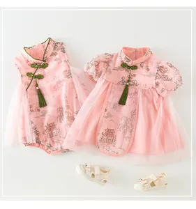 Détail d'une robe chinoise rose pour bébé avec motifs floraux et boutons chinois verts