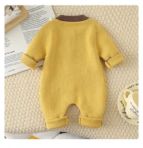 Detail of yellow knit baby romper with brown ribbed collar on a cozy textured blanket