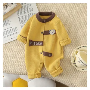 Detailed knit texture of yellow baby romper with a cute bear patch and striped ribbing