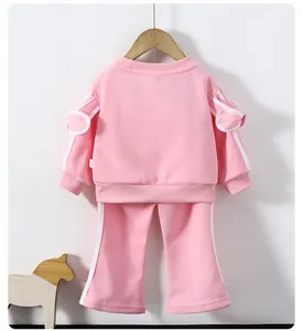 Détail du survêtement rose pour fille avec nœuds 3D et bandes latérales