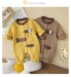 Detail of infant knit rompers in yellow and brown featuring cute bear embroidery and ribbed cuffs