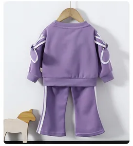 Détail de l'ensemble sweat violet pour filles avec rayures blanches et nœuds décoratifs