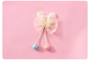 Détail de la pince à cheveux oreilles de souris rose avec sequins et nœud étoilé