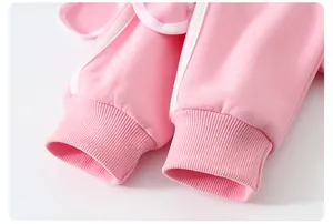 Détail du bord-côte du sweat en coton rose avec bande latérale décorative blanche