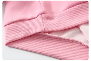 Détail de l'ourlet côtelé et des coutures internes sur ce sweat rose pour fille