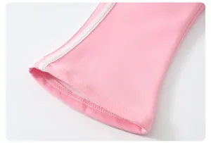 Détail du poignet d'un sweat-shirt rose avec trois bandes blanches et coutures douces