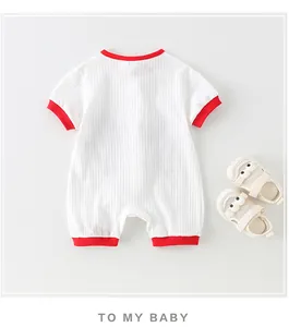 Détail d'un barboteuse bébé à manches courtes avec bordure rouge contrastée
