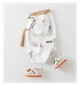 Details von Baby-Tang-Anzug mit Drachenmuster und passenden Bären-Sandalen