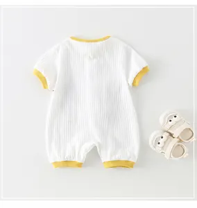 Détail macro du body pour bébé en coton blanc côtelé avec bordure jaune douce