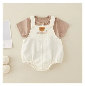 Detail of baby cotton set showing brown bear embroidery and soft ribbed fabric texture