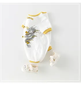 Détail de grenouillère bébé avec motif dragon et boutons chinois traditionnels