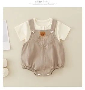 Detail of baby ribbed cotton set with bear embroidery and buttoned dungarees