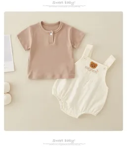 Detail of baby cotton rib t-shirt and overall set with cute bear embroidery