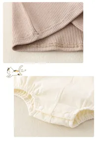 Detail view of cotton baby bodysuit showing stitching, ribbed fabric, and snap buttons