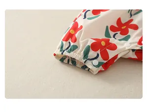 Detail eines Babybodys mit Blumenmuster, elastischen Bündchen und Druckknöpfen