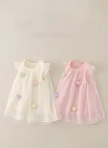 Detailansicht flachgelegter Kleinkind-Tüllkleider mit bunten Herz-Patches und Rüschen