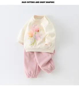 Detail of baby cotton tracksuit set with tulip print and snap button shoulder closure