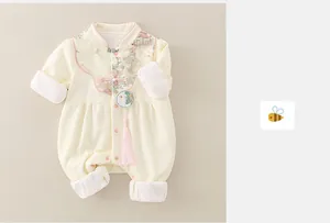 Détail d'un barboteuse pour bébé avec boutons chinois et un gland en soie rose