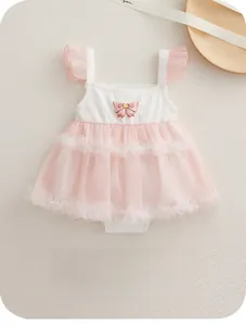 Flat lay of pink mesh baby bodysuit with ruffled sleeves and bow on a wooden tray