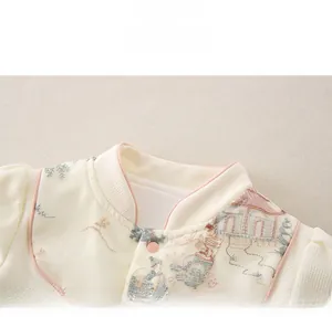 Détail du col avec bordure rose et broderie chinoise sur barboteuse en coton bébé