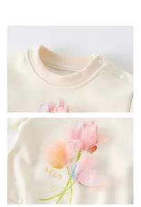 Detail of cream waffle cotton sweatshirt featuring pink tulip print and shoulder buttons