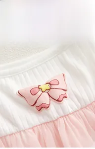 Detail of pink 3D bow decoration on white ribbed cotton baby girls bodysuit dress