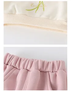 Detail of ribbed hem on beige tulip sweatshirt and elastic waist on pink knit trousers