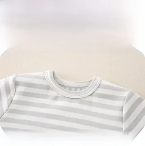 Close-up of the soft cotton crew neck and fine stitching on a green striped baby shirt