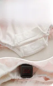 Detail of baby bodysuit snap button closure and fluorescent safety testing display