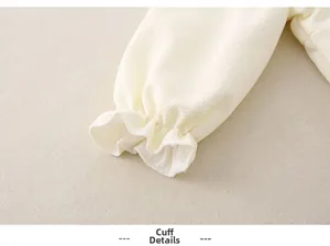 Détail des poignets élastiques à volants et tissu gaufré pour barboteuse bébé
