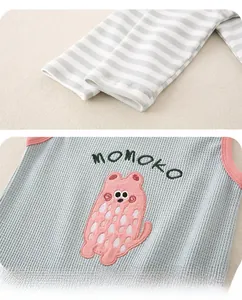 Detail of baby striped sleeves and mint green waffle knit vest with bear embroidery