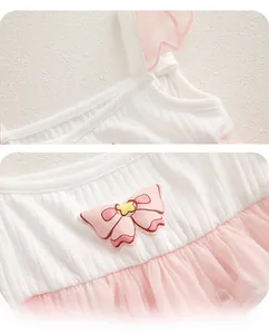 Detail of pink embroidered bow and ribbed cotton fabric on baby girl dress