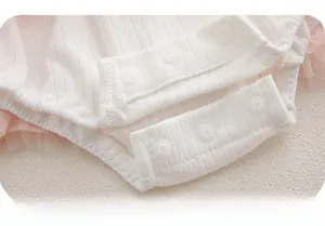 Detail shot of three snap buttons on pink ribbed cotton baby romper for easy dressing