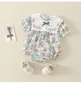 Detail von Baby-Body mit Erdbeerprint, Blumenstickerei und Schleifenakzent für Mädchen