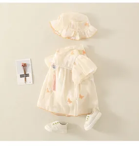 Dettaglio del vestito body neonata con ricamo a farfalla e nappe rosa decorative