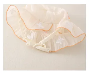 Dettaglio cappello sole neonata con ricamo a farfalla e bordo smerlato arancione
