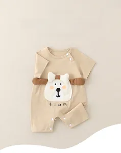 Detail of baby cotton romper featuring a 3D cartoon lion patch and snap button closure