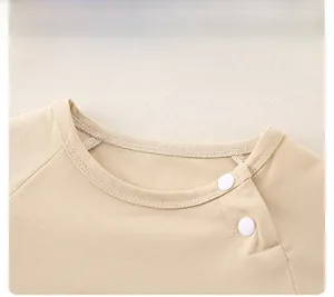 Detail of snap button shoulder on soft cotton baby romper for easy dressing