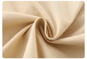 Close-up of soft beige cotton knit fabric texture with gentle folds for baby rompers