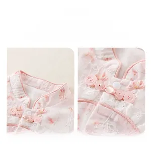 Detail of pink baby romper with Chinese collar, floral patterns and delicate lace trim