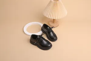 Detail of children's black brogue shoes featuring classic perforated wingtip patterns