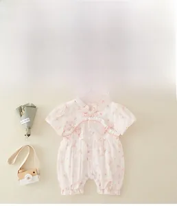 Detail view of pink floral baby romper featuring traditional Chinese knots and ruffle trim