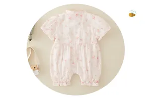 Detail of pink newborn romper with vintage floral patterns and ruffled hem design