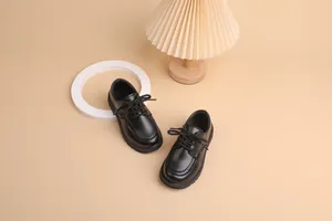 Detailed view of kids black brogue shoes with lace-up design and durable rubber soles