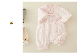 Detail of pink floral baby romper featuring traditional frog buttons and lace collar