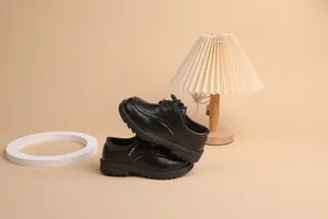 Detailed view of black Oxford shoes for boys featuring classic brogue carved patterns