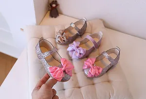 Detailed view of girls' glitter Mary Jane shoes with large satin bows in three colors