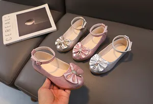 Dettaglio di paillettes scintillanti e fiocco di strass sulle scarpe Mary Jane bimba