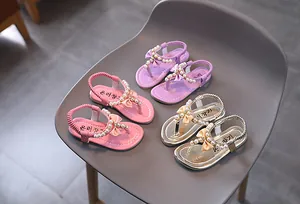 Vista detallada de sandalias para niñas con perlas decorativas y lazos de colores