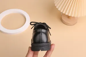 Close-up of black matte leather boys dress shoe showing detailed heel stitching and soft sole